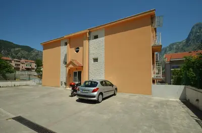 a car parked in a parking lot next to a building at Tea Lux Apartment in Kotor