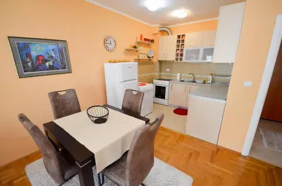 a kitchen and dining room with a table and chairs at Tea Lux Apartment in Kotor