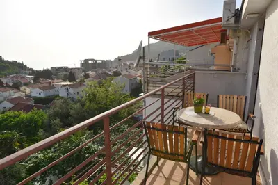 a balcony with a table and chairs and a view at Guest House Jedro in Petrovac na Moru