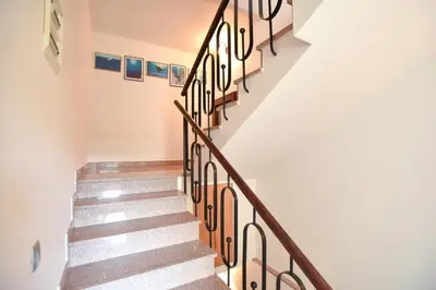 a staircase in a house with wooden railings at Guest House Jedro in Petrovac na Moru