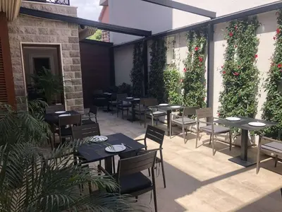a restaurant with tables and chairs on a patio at Hotel Vela in Budva