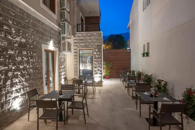 a restaurant with tables and chairs on a patio at Hotel Vela in Budva