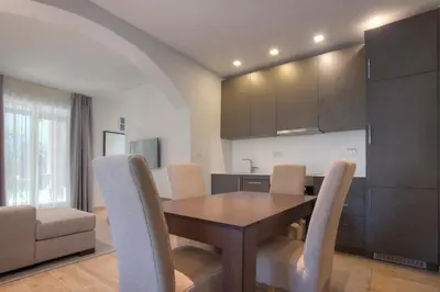 a kitchen and dining room with a wooden table and chairs at Hotel Vela in Budva