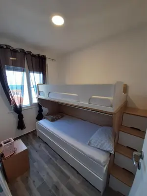 a small room with a bunk bed and a window at Apartments Marina in Utjeha