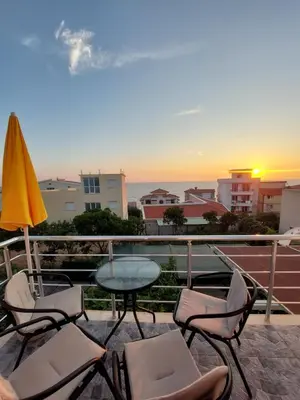 a balcony with chairs and a table and an umbrella at Apartments Marina in Utjeha