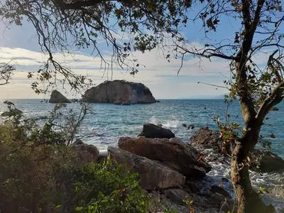 a view of a beach with a rock in the water at Apartments Marina in Utjeha