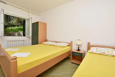 a bedroom with two beds and a window at Apartments and Rooms Iva in Petrovac na Moru