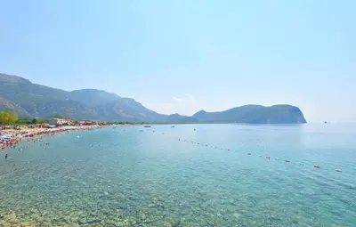 a beach with a group of people in the water at Apartments Siljak in Petrovac na Moru