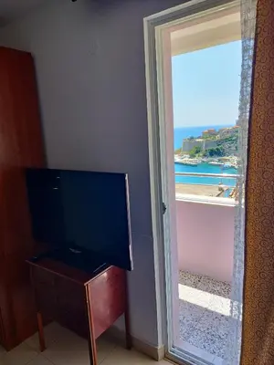a room with a television and a door to a beach at Cosy Apartment in Ulcinj with Sea View - 40 m² in Ulcinj