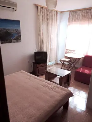 a bedroom with a bed and a tv and a couch at Modern Studio with Sea View - Ulcinj - 25 m² - Balcony in Ulcinj