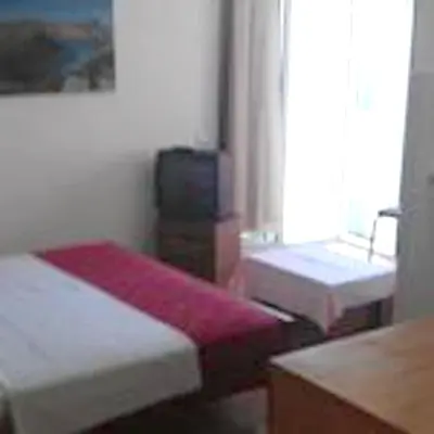a room with two beds and a tv and a window at Modern Studio with Sea View - Ulcinj - 25 m² - Balcony in Ulcinj
