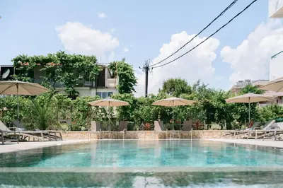 a swimming pool with chairs and umbrellas at B&B Lovac in Ulcinj