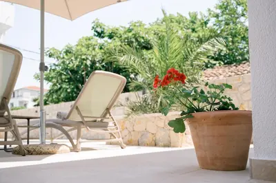 a patio with two chairs and a potted plant at B&B Lovac in Ulcinj