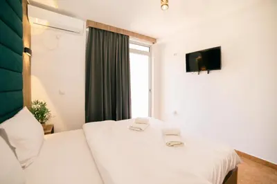 a bedroom with a bed with two towels on it at Hotel Dajti in Ulcinj