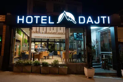 a hoteldain sign in front of a restaurant at night at Hotel Dajti in Ulcinj