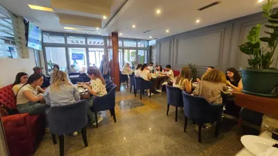 a group of people sitting at tables in a restaurant at Hotel Dajti in Ulcinj
