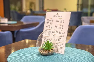 a pineapple sitting on a table next to a menu at Hotel Dajti in Ulcinj