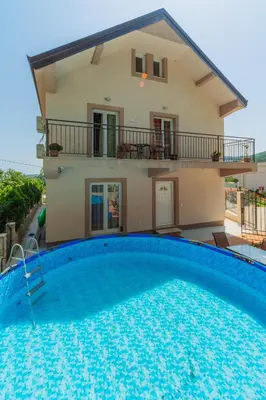 a villa with a swimming pool in front of a house at Villa Sunny Hill in Budva
