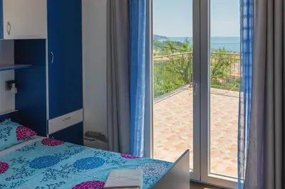 a bedroom with a bed and a view of the beach at Villa Sunny Hill in Budva