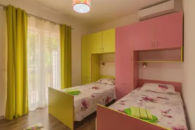 two beds in a room with colorful cabinets at Villa Sunny Hill in Budva