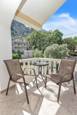 a patio with two chairs and a table on a balcony at Apartment Kalle in Kotor
