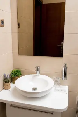 a white sink in a bathroom with a mirror at IPN APARTMENTs in Podgorica