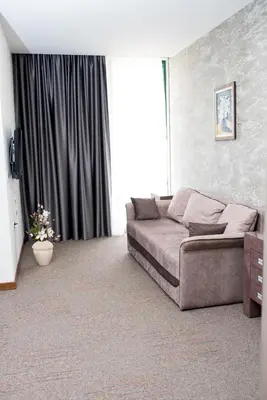 a living room with a couch and a large window at IPN APARTMENTs in Podgorica