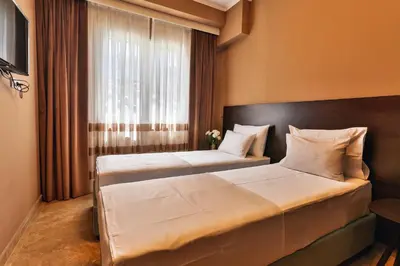 two beds in a hotel room with a window at Regina del Mare in Bar