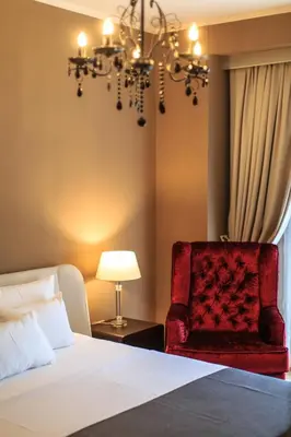 a bedroom with a bed and a chair and a chandelier at Regina del Mare in Bar