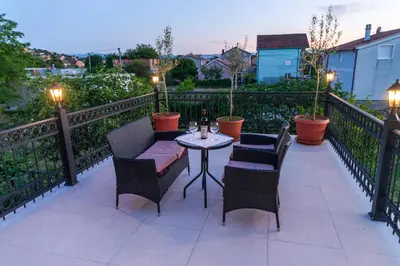 a patio with chairs and a table on a balcony at Apartman Mona in Podgorica