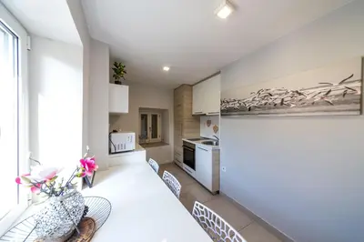 a kitchen with a white table and some chairs at Lux - Apartment BCN in Budva