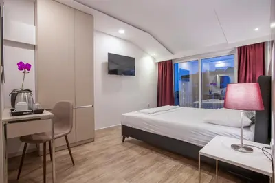 a hotel room with a bed and a desk and a window at Casa Mia in Budva