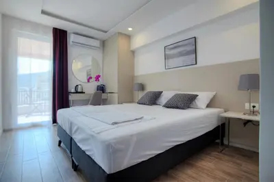 a bedroom with a large white bed and a desk at Casa Mia in Budva