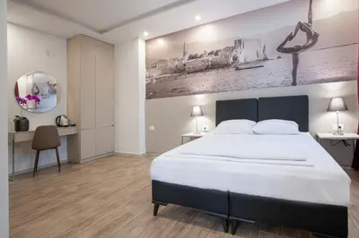 a bedroom with a large white bed and a desk at Casa Mia in Budva