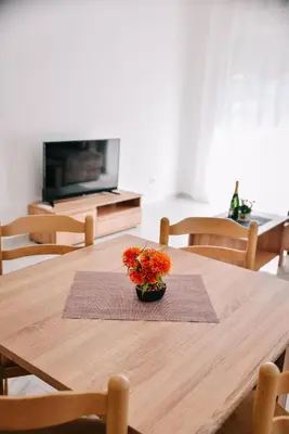 a wooden table with a vase of flowers on it at Riva Luxury in Ulcinj