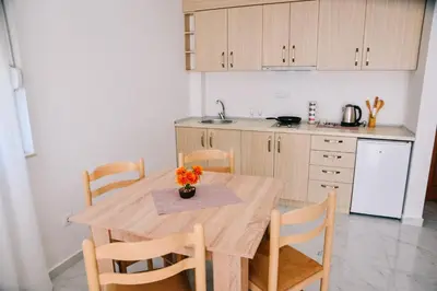 a kitchen with a wooden table with chairs and a sink at Riva Luxury in Ulcinj