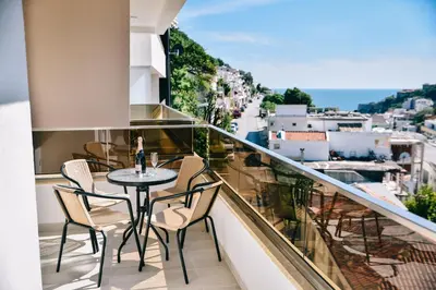 a balcony with a table and chairs and a view of a city at Riva Luxury in Ulcinj