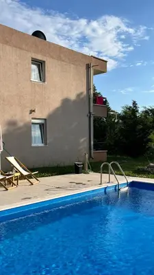 a swimming pool in front of a house at Guesthouse P&A in Budva