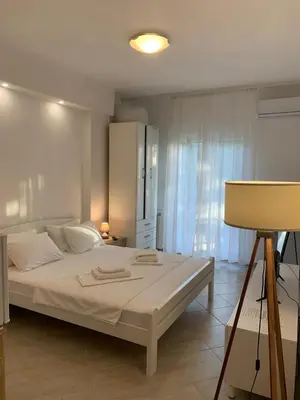 a bedroom with a large white bed and a lamp at Guesthouse P&A in Budva