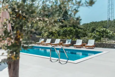 a pool with chaise lounge chairs and a swimming pool at Villa Mina in Kotor
