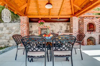 a patio with a table and chairs and a brick fireplace at Villa Mina in Kotor