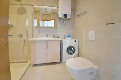 a bathroom with a toilet sink and a washing machine at Apartment Old Town Budva in Budva
