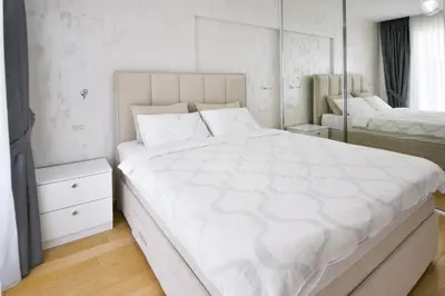 a bedroom with a large white bed and a mirror at Apartment Old Town Budva in Budva