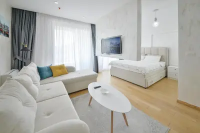 a white living room with a couch and a table at Apartment Old Town Budva in Budva