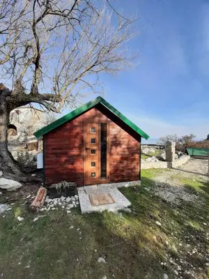a small cabin with a green roof in a field at Livari Viewpoint in Livari