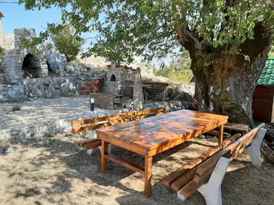 a wooden table and benches under a tree at Livari Viewpoint in Livari