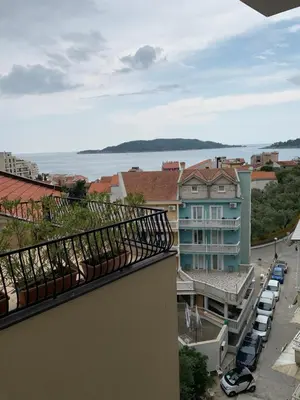 a balcony of a building with a view of the ocean at Butterfly Apartman in Rafailovici