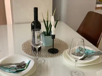 a table with two glasses and a bottle of wine at Butterfly Apartman in Rafailovici
