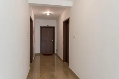 an empty hallway with white walls and a brown door at Apartman Natalia in Budva