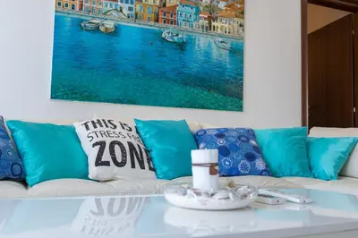 a living room with a white couch with blue pillows at Apartman Natalia in Budva